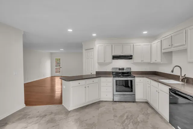 a kitchen with stainless steel appliances granite countertop a sink stove and cabinets