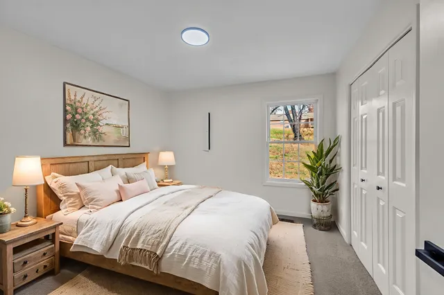 a bedroom with a bed and a painting on the wall