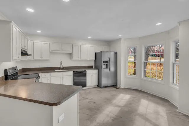 a kitchen with stainless steel appliances granite countertop a sink a refrigerator and a stove