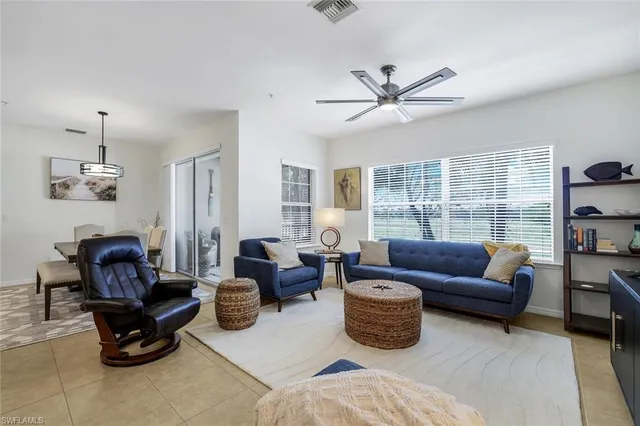 a living room with furniture a ceiling fan and a window