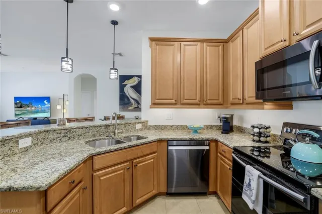 a kitchen with stainless steel appliances granite countertop a sink stove and microwave