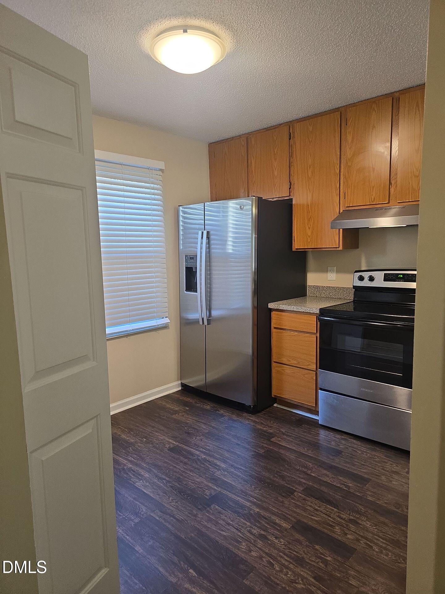 7825 Stephanie Lane Raleigh, NC 27615 - Photo 3 of 20 a kitchen with stainless steel appliances a refrigerator and a stove top oven