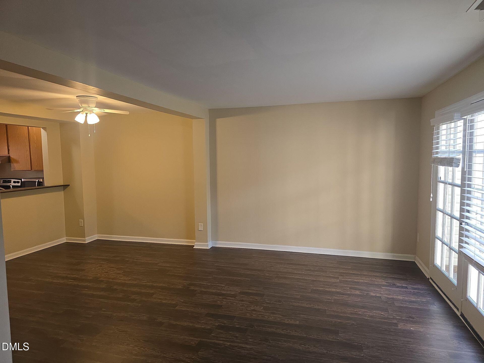 7825 Stephanie Lane Raleigh, NC 27615 - Photo 7 of 20 a view of an empty room with wooden floor and a window