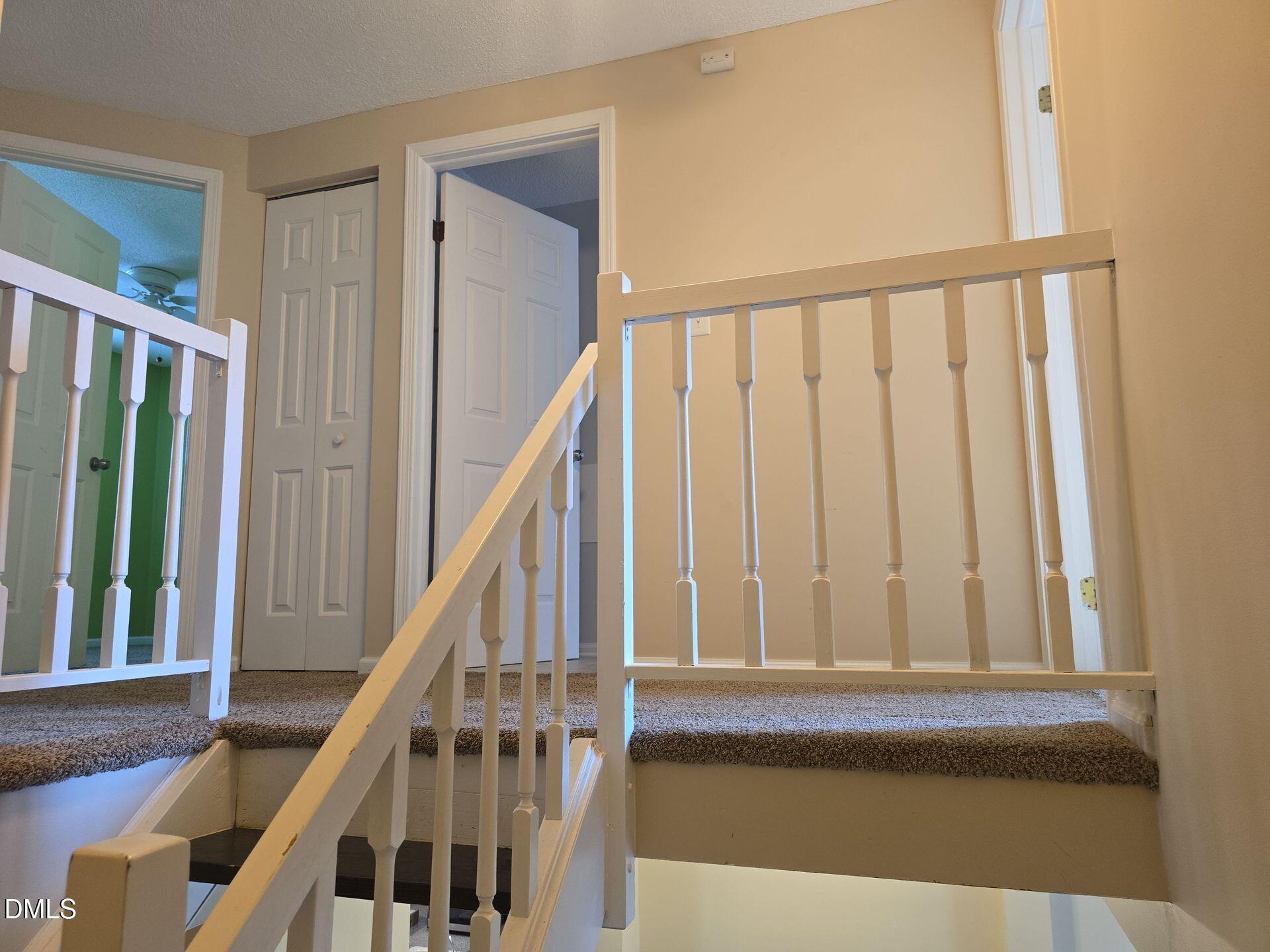 7825 Stephanie Lane Raleigh, NC 27615 - Photo 8 of 20 a view of staircase with railing and white walls