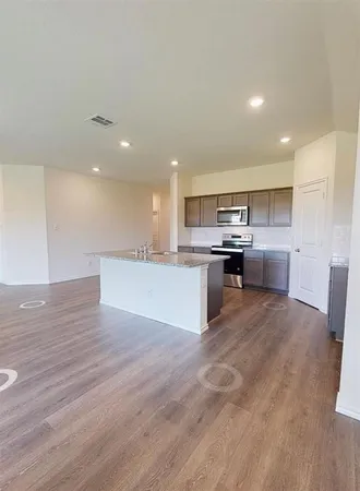 a large kitchen with stainless steel appliances granite countertop a large counter top and a stove top oven