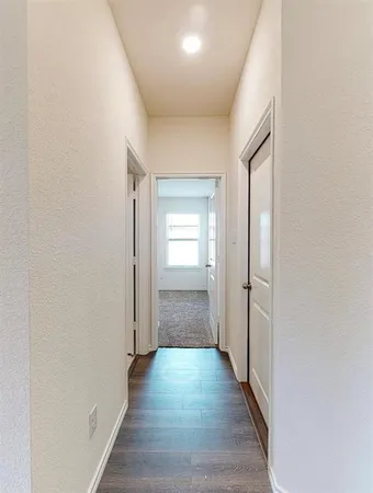a view of a hallway with wooden floor and closet