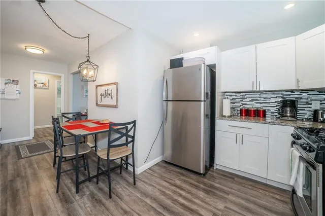 a kitchen with refrigerator and wooden floor