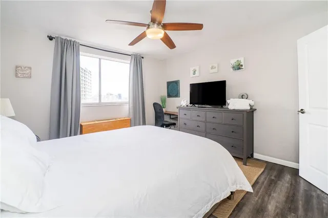 a spacious bedroom with a bed and a flat screen tv