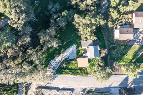 an aerial view of residential houses with outdoor space and trees