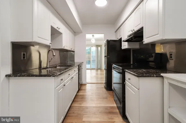 a large kitchen with stainless steel appliances kitchen island granite countertop a large counter top space a stove a microwave and cabinets