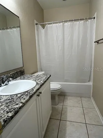a bathroom with a granite countertop sink a toilet and a mirror