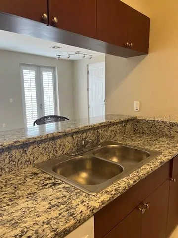 a kitchen with granite countertop a sink and a stove
