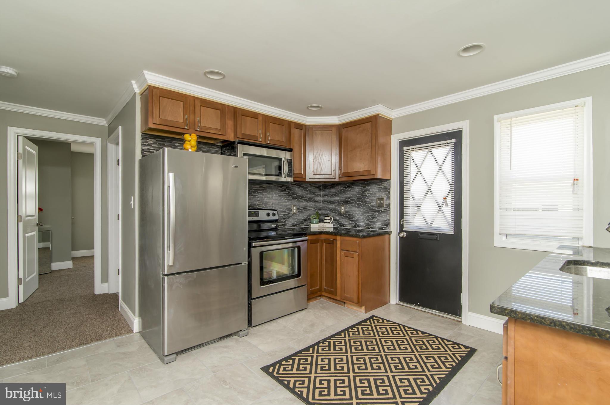 1210 3rd Road Baltimore, MD 21220 - Photo 12 of 26 a kitchen with granite countertop a refrigerator and a sink