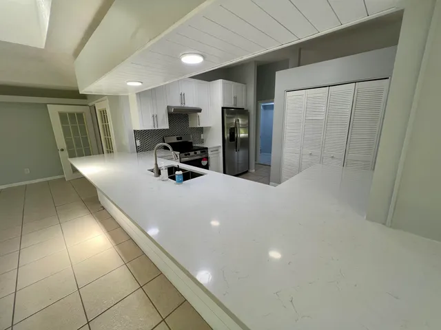 a kitchen with stainless steel appliances a sink a counter top space cabinets and a counter top space