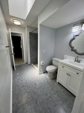 a bathroom with a double vanity sink toilet and mirror