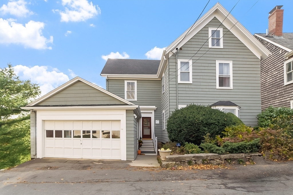 a view of a house with a garage and plants