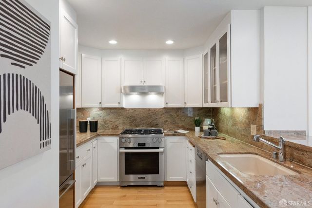 a kitchen with stainless steel appliances granite countertop a sink stove and refrigerator