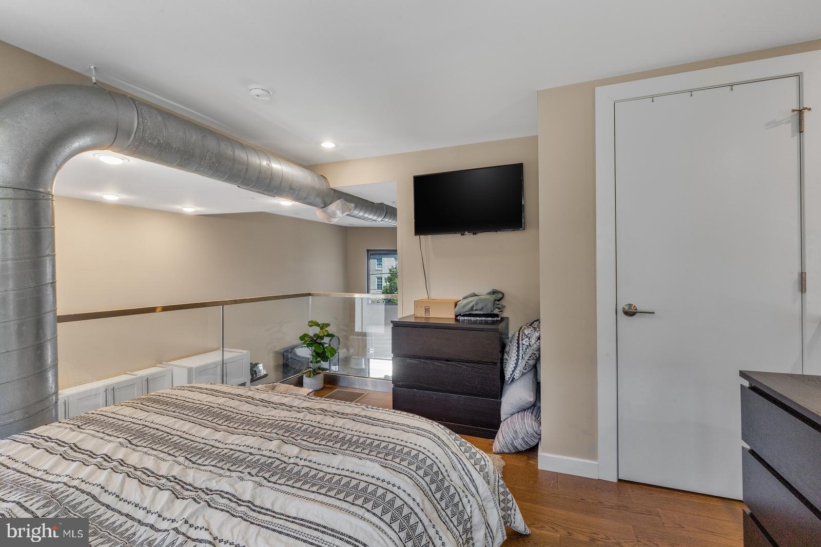 1142 Crease Street, Unit 2L Philadelphia, PA 19125 - Photo 11 of 17 a bedroom with a bed a television and a large window