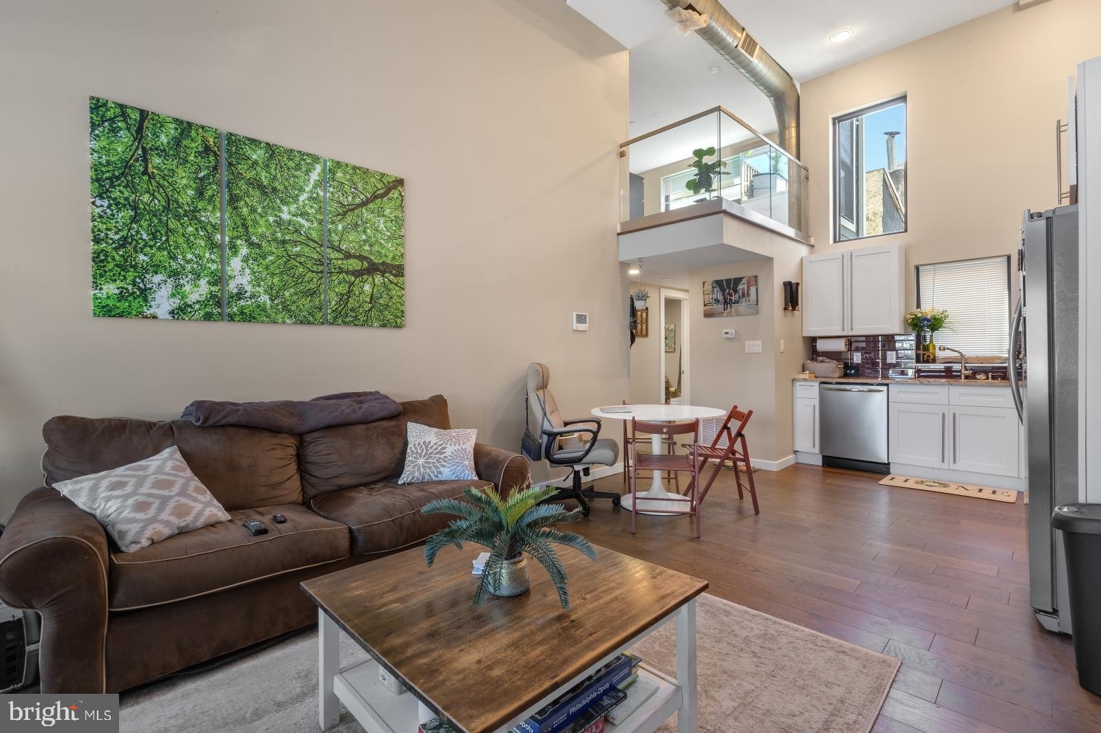 1142 Crease Street, Unit 2L Philadelphia, PA 19125 - Photo 7 of 17 a living room with furniture a rug kitchen view and a large window