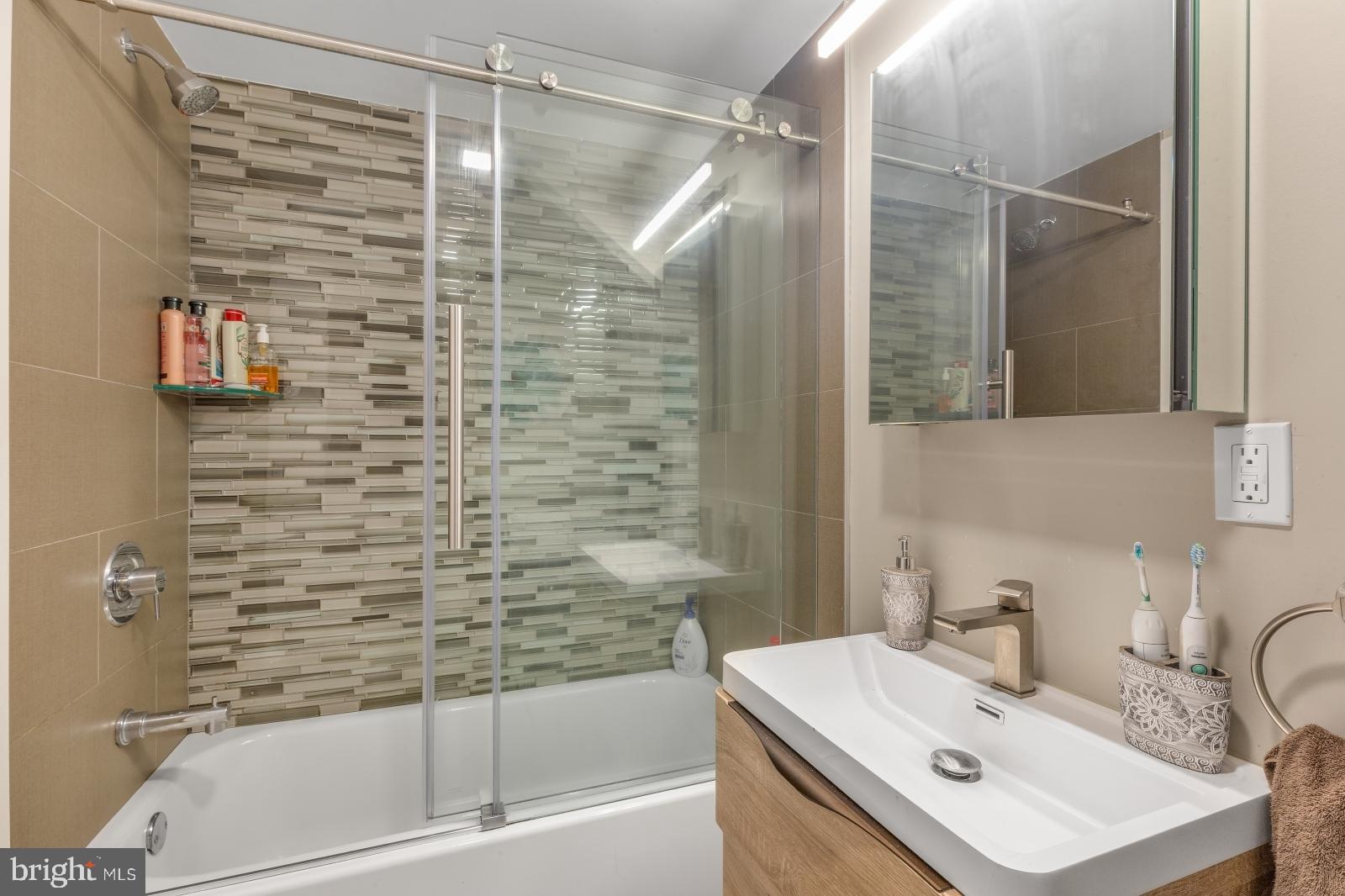1142 Crease Street, Unit 2L Philadelphia, PA 19125 - Photo 10 of 17 a bathroom with a sink mirror and a bathtub