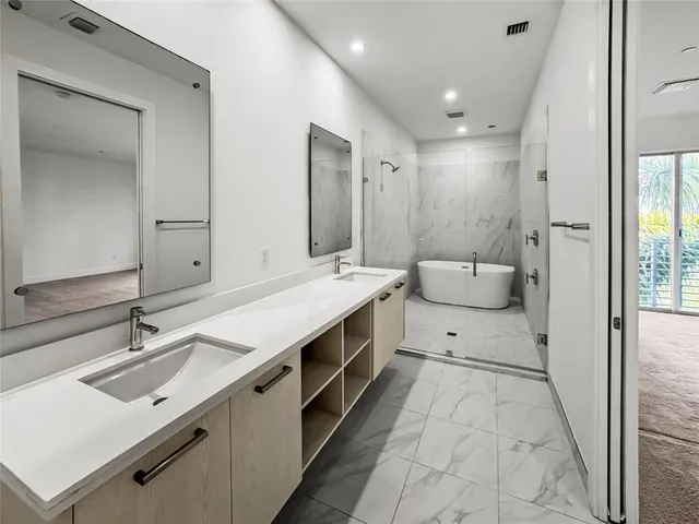 a spacious bathroom with a double vanity sink a mirror and a shower