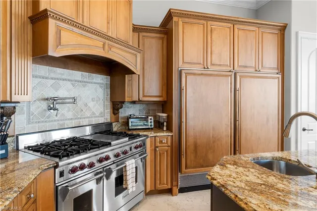 a kitchen with granite countertop a stove and a refrigerator