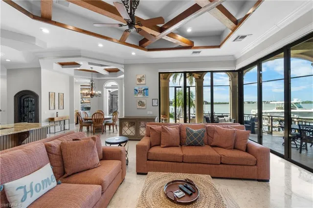 a living room with furniture a ceiling fan and a large window