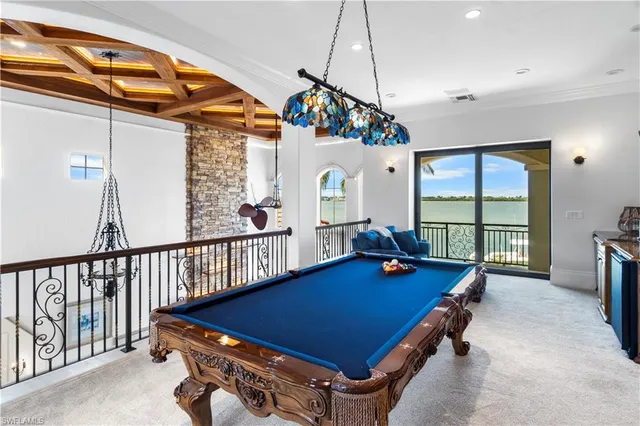 a room with furniture pool table and windows