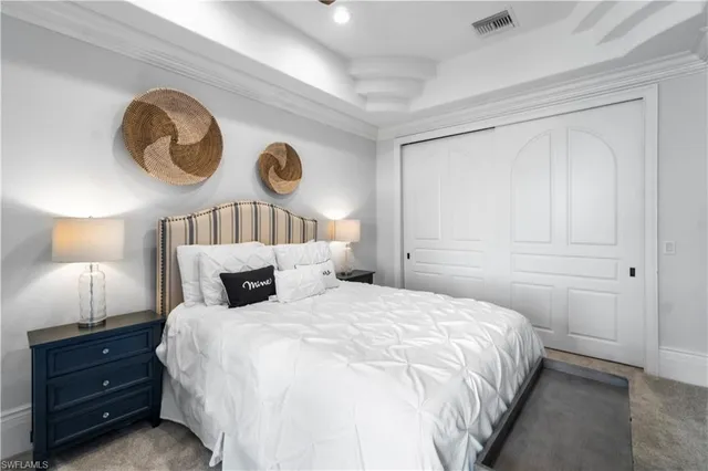 a bedroom with a bed and a lamp on dresser