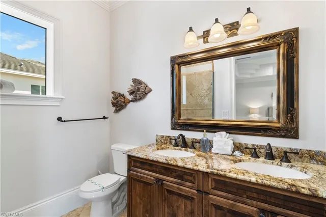 a bathroom with a granite countertop toilet a sink and mirror