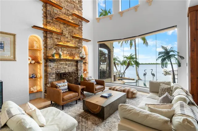 a living room with furniture fireplace and floor to ceiling windows