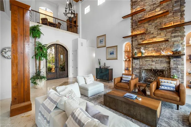 a living room with furniture a fireplace and a chandelier
