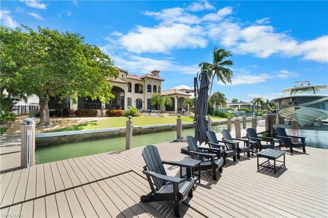 a view of a swimming pool with chairs and table on the wooden floor