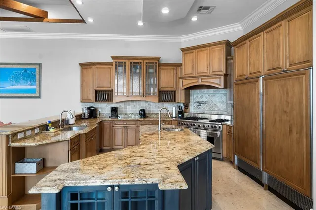 a kitchen with kitchen island granite countertop wooden cabinets a stove top oven a sink and dishwasher
