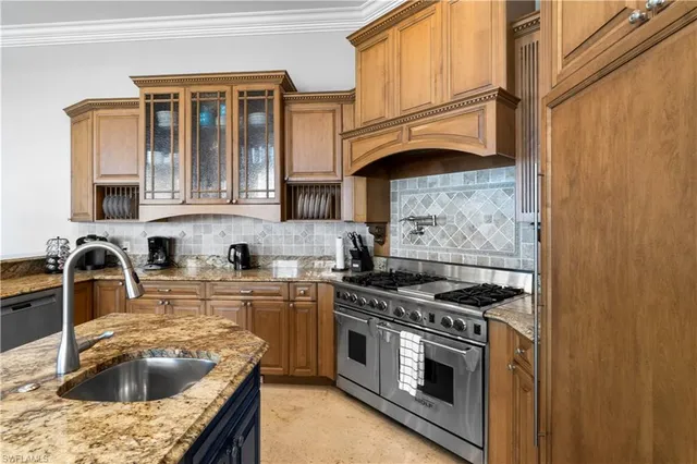 a kitchen with granite countertop a sink stove and cabinets