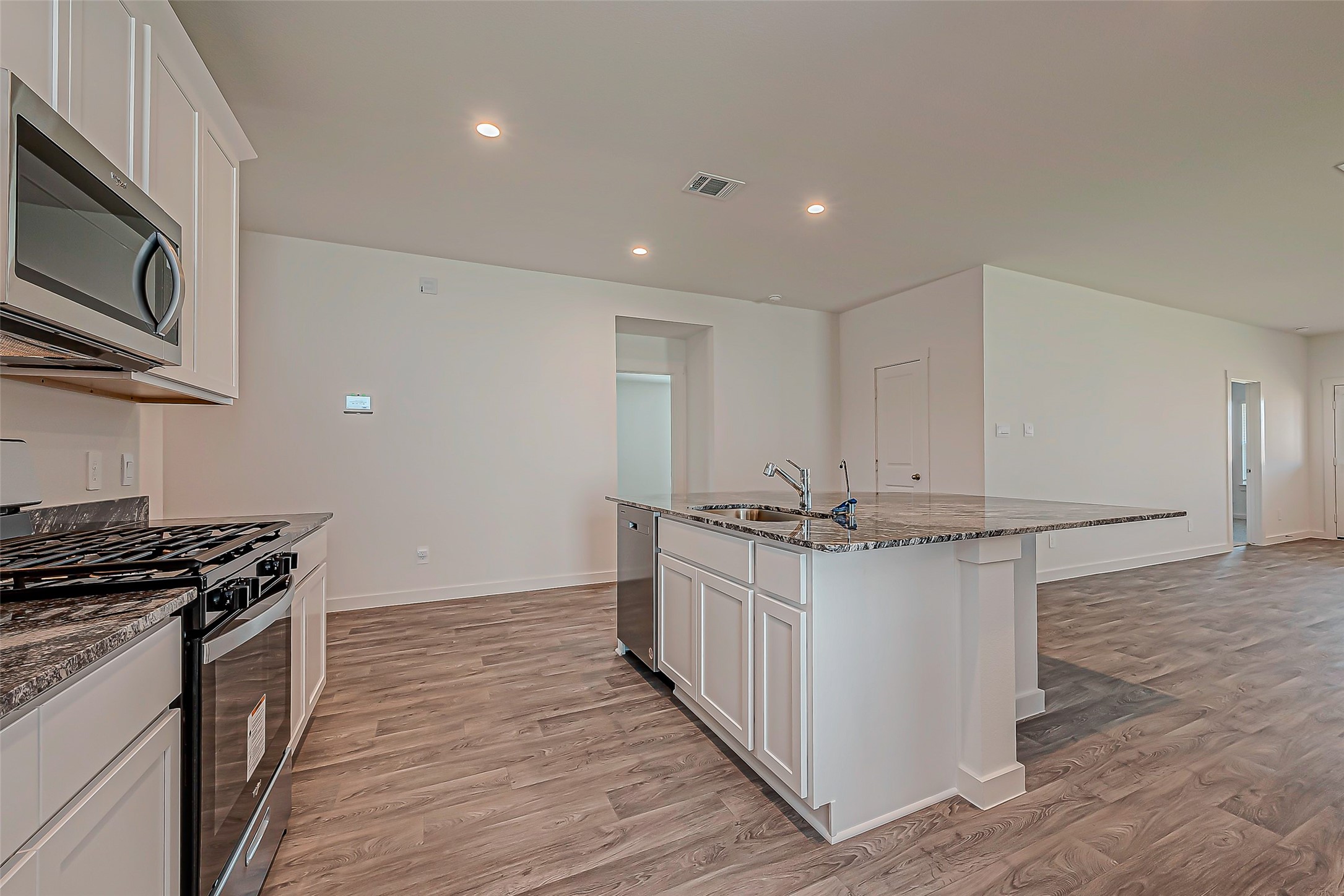 6108 Ryon Falls Drive Rosenberg, TX 77469 - Photo 12 of 39 a kitchen with stainless steel appliances a stove top oven a sink and a refrigerator