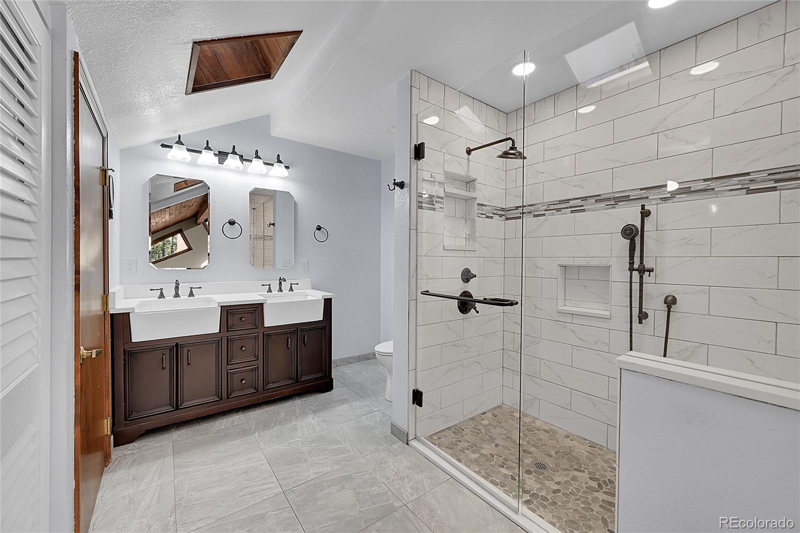 348 Nova Road Pine, CO 80470 - Photo 26 of 50 a spacious bathroom with a shower sink and mirror