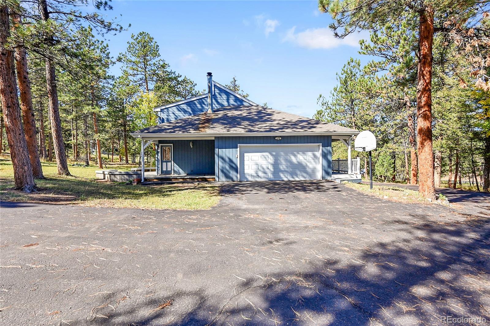 348 Nova Road Pine, CO 80470 - Photo 31 of 50 a front view of a house with a yard and a garage