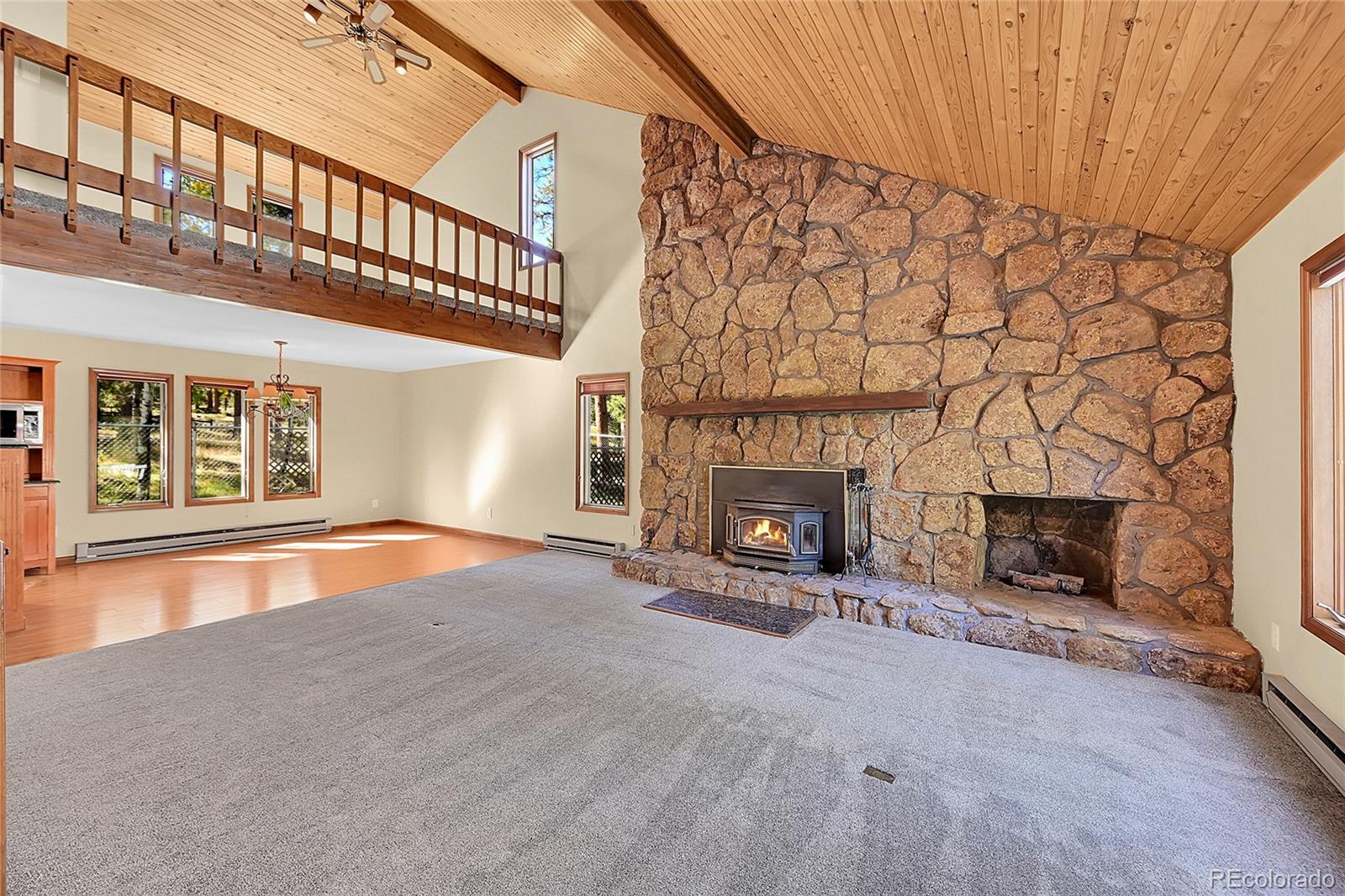 348 Nova Road Pine, CO 80470 - Photo 5 of 50 an empty room with windows and fireplace