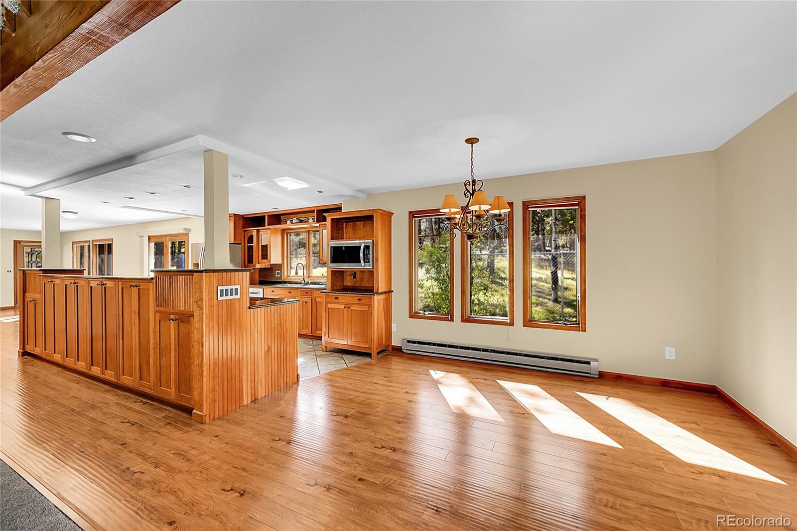 348 Nova Road Pine, CO 80470 - Photo 9 of 50 a view of an empty room with wooden floor and windows