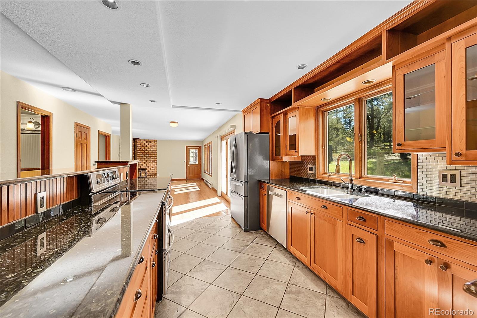 348 Nova Road Pine, CO 80470 - Photo 10 of 50 a large kitchen with kitchen island granite countertop a large counter top space and stainless steel appliances