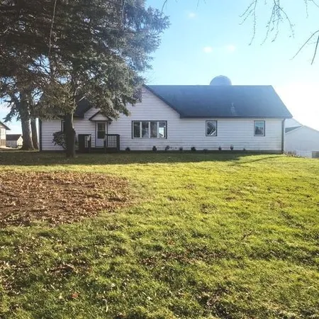a front view of a house with a large tree