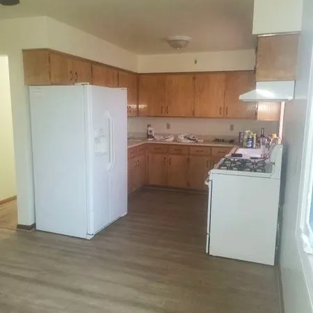 a kitchen with a refrigerator sink stove and cabinets