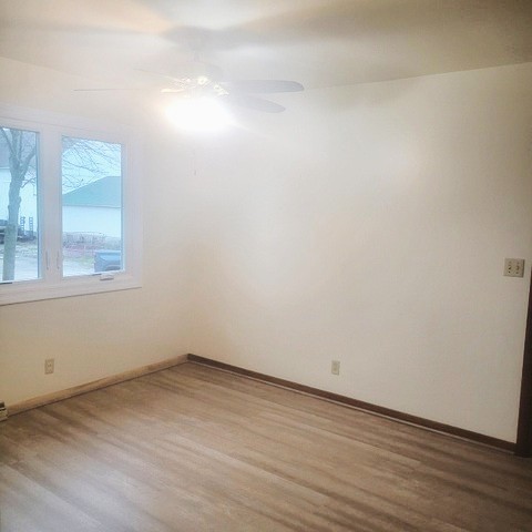 45-w005 Berner Road, Unit A Hampshire, IL 60140 - Photo 5 of 7 an empty room with wooden floor and windows