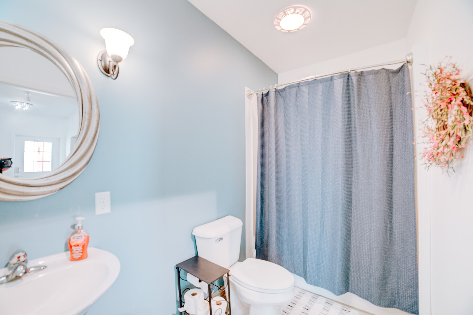 100 East Lyle Street Milford, IL 60953 - Photo 25 of 37 a bathroom with a sink a toilet a mirror and shower curtain