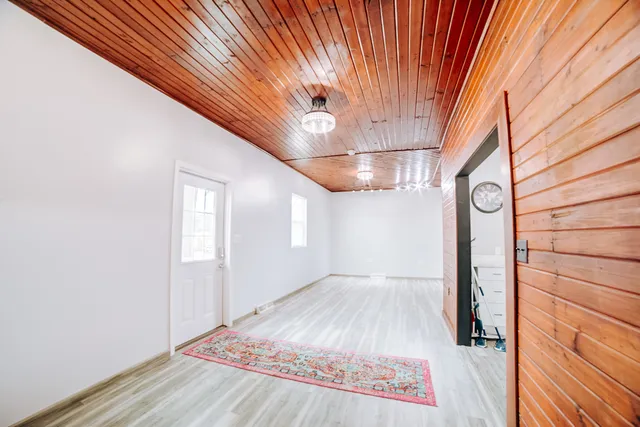 a view of empty room with window and wooden floor