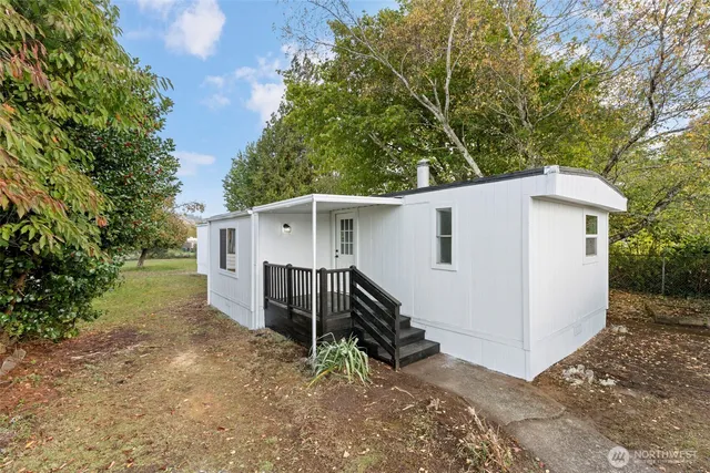 a view of a house with backyard and trees