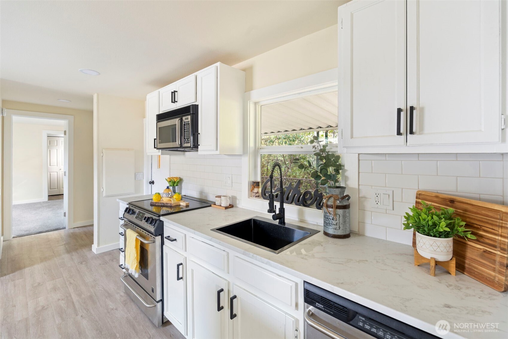 254 Ho Hum Lane Aberdeen, WA 98520 - Photo 5 of 27 a kitchen with a sink a potted plant and a wooden floor