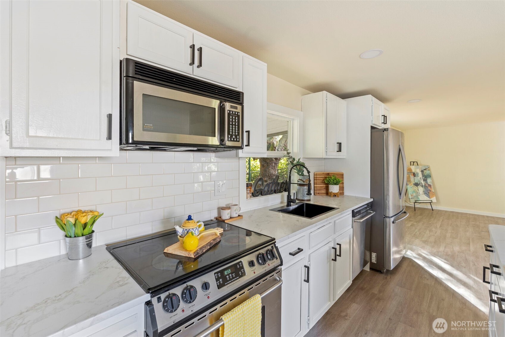 254 Ho Hum Lane Aberdeen, WA 98520 - Photo 6 of 27 a kitchen with stainless steel appliances a stove a sink cabinets and a wooden floor
