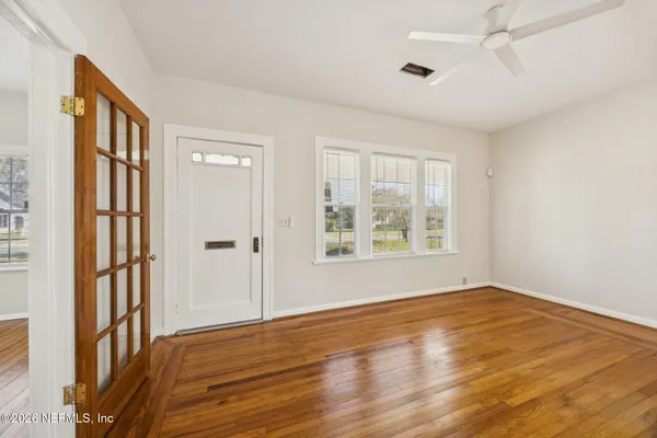 a view of an empty room with glass door and a window